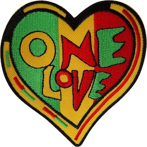 May include: A heart-shaped embroidered patch featuring vertical stripes of green, yellow, and red. The text ONE LOVE is stitched across the center in a bold, stylized font. The entire patch is outlined with a thick black border for definition.