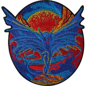 Op de afbeelding: Een ronde geborduurde patch met een centraal blauw gevleugeld wezen met puntige oren en een staart. De achtergrond toont een grote gele zon omringd door rode en blauwe wolken. Het ontwerp is omlijst door een zwarte rand met vleugelachtige uitsteeksels.
