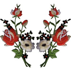 Puede incluir: Un par de parches bordados florales simétricos que presentan grandes rosas rojas y blancas, flores blancas más pequeñas y hojas y tallos de color verde oscuro. El diseño incluye un detallado trabajo de hilo que resalta los pétalos y el follaje.