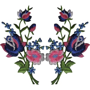 Puede incluir: Un par de parches bordados florales simétricos que presentan grandes rosas de color azul oscuro y rosa, flores más pequeñas de color azul claro y tallos verdes con hojas. El intrincado bordado muestra una paleta de colores vibrantes con hilos azul marino, magenta y azul cielo sobre un fondo liso.