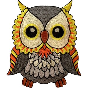 May include: An embroidered owl patch featuring a grey head and body with white and grey chest feathers. The owl has large yellow and black eyes, a brown beak, and a vibrant yellow and orange ruffled collar. The wings have orange and yellow stripes.
