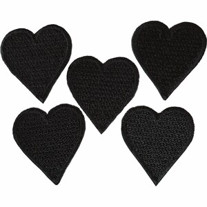 Può includere: Cinque toppe ricamate individuali a forma di cuore nero disposte in un gruppo. Ogni toppa presenta una costruzione in filo denso e testurizzato che forma una solida sagoma a cuore con una base appuntita e un bordo superiore arrotondato.