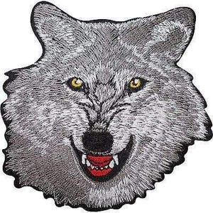 Peut inclure: Un écusson brodé représentant la tête d'un loup gris avec une texture de fourrure détaillée, des oreilles pointues et des yeux jaunes perçants. Le loup a un nez noir et une gueule ouverte révélant des dents blanches et une langue rouge vif.