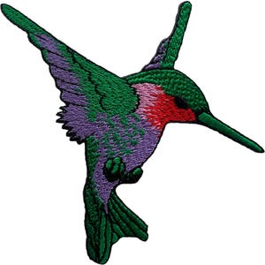 Puede incluir: Un parche bordado con la forma de un colibrí en vuelo. El ave presenta una garganta de color rojo brillante, cabeza y alas verdes, y un cuerpo y cola de color púrpura. Todo el diseño está delineado con hilo negro, creando una silueta definida.