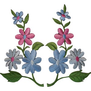 Könnte beinhalten: Zwei symmetrische, gestickte Blumenaufnäher mit Stängeln, grünen Blättern und Blüten in Hellblau, Mittelblau und Pink. Jeder Aufnäher zeigt eine vertikale Anordnung von drei verschiedenen Blumentypen mit detaillierten Stickereien.