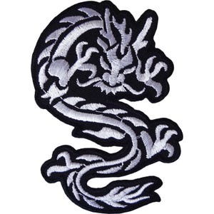 Puede incluir: Un parche bordado que presenta un dragón estilizado en hilo blanco sobre un fondo negro sólido. El dragón se muestra en una postura serpentina curva con detalles intrincados en sus escamas, cuernos y bigotes fluidos.