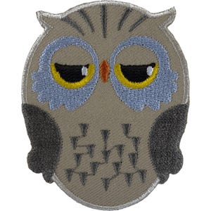 May include: An embroidered owl patch featuring a light brown body, dark grey wings, and light blue circular eye patches. The owl has yellow eyes with black pupils, a small orange beak, and dark grey geometric markings on its chest area.