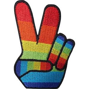 May include: An embroidered patch in the shape of a hand making a peace sign. The design features horizontal stripes in a rainbow colour sequence of red, orange, yellow, green, blue, and violet, all outlined with a thick black stitched border.