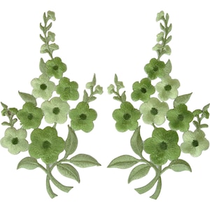 Puede incluir: Dos parches florales bordados simétricos con hilos en tonos verde claro y oscuro. Cada parche muestra una disposición vertical de flores de cinco pétalos y hojas puntiagudas, creando un diseño botánico coherente para aplicar en telas.