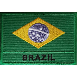 Puede incluir: Un parche bordado rectangular que muestra la bandera de Brasil con un fondo verde, un rombo amarillo y un globo azul con estrellas blancas y una banda blanca. La palabra BRAZIL está bordada en letras mayúsculas negras en la parte inferior.