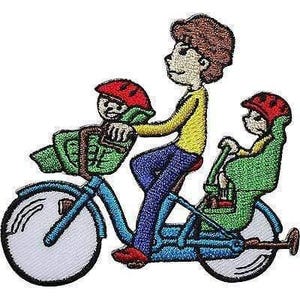 May include: An embroidered patch featuring a person with brown hair wearing a yellow long-sleeve shirt and blue trousers riding a blue bicycle. The bicycle has a green front basket and a green rear seat, each carrying a small figure wearing a red helmet.