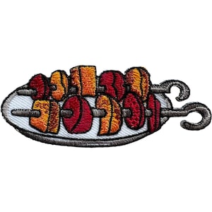 May include: An embroidered patch featuring two metal skewers loaded with alternating pieces of red and orange food items, arranged horizontally on a white oval plate with a dark grey border and visible stitching details throughout the design.