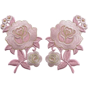 Puede incluir: Dos parches bordados simétricos con rosas de color rosa claro y detalles en hilo dorado. Cada parche muestra una rosa central grande, un capullo más pequeño y un grupo de flores diminutas en la parte superior, unidos por tallos y hojas.