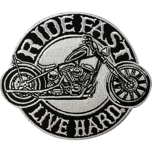 May include: A circular embroidered patch featuring a black and white motorcycle graphic in the centre. The text RIDE FAST is arched across the top, and the text LIVE HARD is arched across the bottom, both in white capital letters on a black background.