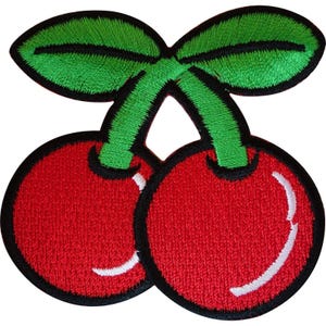 Pode incluir: Um emblema bordado apresentando duas cerejas vermelho-brilhantes com um reflexo branco em cada fruta. As cerejas estão ligadas por dois caules verdes que se estendem para cima até duas folhas verde-vibrantes. O design é contornado por fio preto.