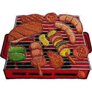 Könnte beinhalten: Ein gestickter Aufnäher, der einen roten Grill mit verschiedenen Lebensmitteln zeigt, darunter ein großes Steak, eine Wurst, ein Spieß mit Fleisch und Gemüse, eine grüne Paprika, ein Stück gelber Kürbis und eine runde Tomatenscheibe.