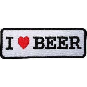 Può includere: Una toppa rettangolare ricamata con sfondo bianco e un bordo nero spesso. Il testo recita I, seguito da un simbolo di cuore rosso e la parola BEER in lettere maiuscole nere in grassetto. Il design è centrato sulla superficie in tessuto.