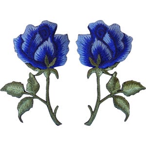 May include: Two identical embroidered patches featuring a blue rose with layered petals in shades of dark and light blue. Each rose has a green stem with three leaves extending from the sides, rendered in detailed thread work on a plain background.