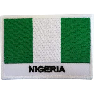 May include: A rectangular embroidered patch featuring the flag of Nigeria, which consists of two vertical green bands on the sides and a white band in the centre. The word NIGERIA is stitched in black capital letters on a white border at the bottom.