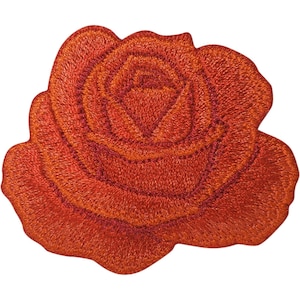 May include: An embroidered patch in the shape of a blooming rose flower. The design features dense stitching in shades of vibrant orange and deep red, creating a textured, layered appearance with visible thread patterns throughout the petals.