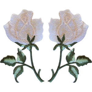 May include: Two identical embroidered patches featuring a white rose blossom with a light cream centre. Each rose has a dark green stem with three detailed leaves extending from the base, showcasing intricate thread work and texture.