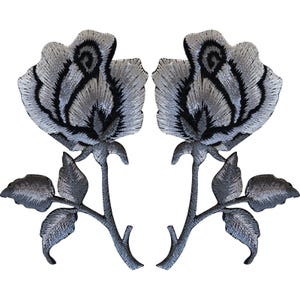 Puede incluir: Dos parches bordados idénticos con un diseño de rosa estilizada. Cada parche muestra una flor de rosa plateada y gris con contornos negros oscuros, un tallo y dos hojas, todo realizado con un detallado trabajo de hilo.