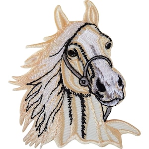 Puede incluir: Un parche bordado que muestra la cabeza de un caballo con pelaje color crema, una mancha blanca en la cara y una crin fluida. El caballo lleva una brida negra fina y el diseño está delineado con costuras negras sobre un fondo blanco.