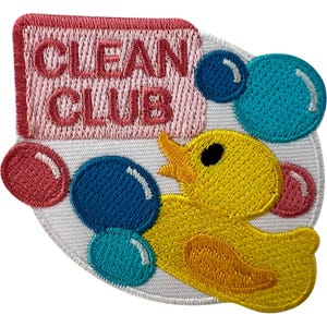 May include: An embroidered patch featuring a yellow rubber duck surrounded by blue, teal, and pink bubbles on a white background. A pink rectangular sign with the dark pink text CLEAN CLUB is positioned above the duck. The patch has a white border.
