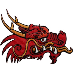 May include: An embroidered patch featuring the head of a red dragon with gold horns and whiskers. The design includes black outlines, white teeth, and a single visible eye with a white iris and black pupil, all rendered in detailed thread work.