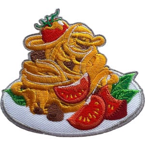 May include: An embroidered patch featuring a plate of yellow pasta topped with a red tomato, sliced red tomatoes, and green basil leaves. The design is rendered in vibrant thread colors with a white background plate and a grey stitched border.