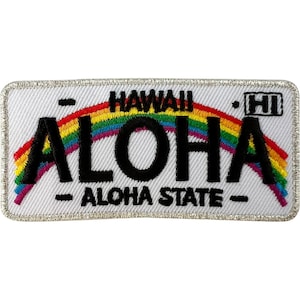 Może przedstawiać: Prostokątna haftowana naszywka z białym tłem i srebrną obwódką. Przedstawia tęczę nad czarnym napisem ALOHA, z napisem HAWAII powyżej, ALOHA STATE poniżej oraz HI w małej ramce po prawej stronie, imitującą tablicę rejestracyjną.