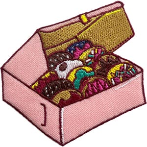 Op de afbeelding: Een geborduurde patch met een lichtroze doos met een open deksel, gevuld met een assortiment kleurrijke, getextureerde lekkernijen in tinten bruin, geel, taling, wit en magenta, omlijnd met een donker kastanjebruine draad.