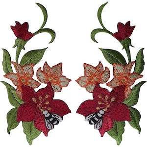 Puede incluir: Dos parches bordados simétricos que presentan flores de color rojo oscuro y naranja similares a lirios con hojas y tallos verdes. Cada parche incluye una pequeña abeja blanca y negra sobre los pétalos rojos inferiores.