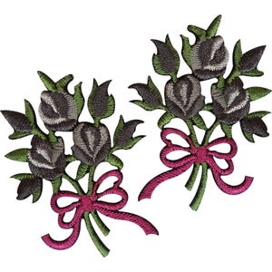 Puede incluir: Dos parches bordados que presentan ramos de capullos de rosa gris oscuro con hojas y tallos verdes, cada uno atado con un lazo de cinta rosa brillante. Los diseños florales son idénticos, mostrando costuras detalladas y composición.