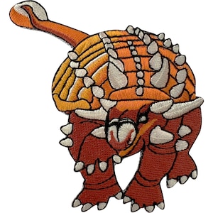 Pode incluir: Um emblema bordado representando um dinossauro anquilossauro em tons de laranja e castanho-avermelhado. O dinossauro tem uma carapaça blindada proeminente com espinhos brancos nas costas e uma cauda longa que termina numa clava.