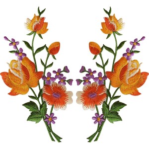 Op de afbeelding: Twee symmetrische geborduurde bloemenpatches met grote oranje en gele rozen, kleinere oranje bloesems en trossen kleine paarse bloemetjes met groene stengels en bladeren. Het borduurwerk toont gedetailleerde texturen van de bloemblaadjes.
