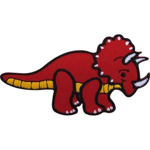 Puede incluir: Un parche bordado termoadhesivo con forma de dinosaurio triceratops. El dinosaurio es principalmente rojo con el vientre amarillo y detalles blancos en los cuernos y la gola. Todo el diseño está delineado con un borde negro grueso y definido.