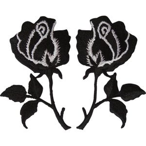 Puede incluir: Dos parches bordados simétricos que presentan rosas negras con detalles de hilo blanco en los pétalos. Cada rosa está unida a un tallo con dos hojas, todo realizado en hilo de bordar negro sólido sobre un fondo blanco liso.
