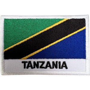 May include: A rectangular embroidered patch featuring the flag of Tanzania with a green upper triangle and a blue lower triangle separated by a black diagonal band edged in yellow. The word TANZANIA is stitched in black capital letters below.