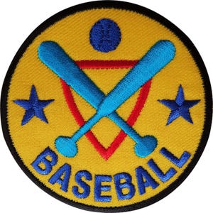 Könnte beinhalten: Ein runder gestickter Aufnäher mit gelbem Hintergrund und schwarzem Rand. Er zeigt zwei gekreuzte hellblaue Baseballschläger, ein rotes Dreieck, zwei blaue Sterne, einen blauen Baseball und das Wort BASEBALL in blauen Großbuchstaben unten.