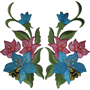 May include: A pair of symmetrical embroidered patches featuring floral arrangements with bright blue and pink flowers, green leaves, and a yellow and black bee resting on the bottom blue flower of each design against a plain white background.