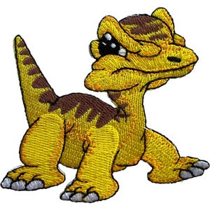 Könnte beinhalten: Ein gestickter Aufnäher, der einen Cartoon-Dinosaurier mit gelber Haut und braunen Streifen zeigt. Die Kreatur hat einen großen Kopf, einen spitzen Schwanz und vier Beine mit grauen Krallen. Das Motiv ist in dichter Stickerei auf weißem Grund.