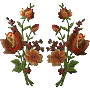 Op de afbeelding: Twee symmetrische geborduurde patches met bloemstukken met grote bruine en rode rozen, kleinere oranje bloesems en donkerbruine accentbloemen. Elke patch bevat groene stengels en bladeren, met gedetailleerd borduurwerk.