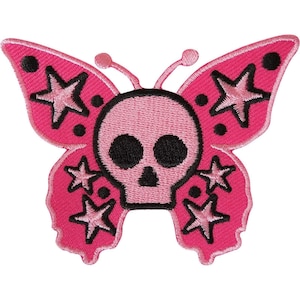 Peut inclure: Un écusson brodé rose vif en forme de papillon avec un crâne rose clair au centre. Les ailes présentent des étoiles aux contours noirs et des points noirs. Le crâne a deux grandes orbites noires et une petite cavité nasale triangulaire noire.