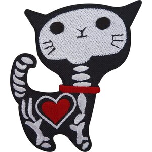 May include: An embroidered patch shaped like a black cat with a white skeletal design. The cat features a white skull face with black eyes, a red collar, and a prominent red heart on its side. The tail and body show white bone details.