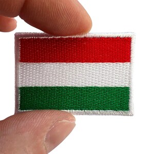 Könnte beinhalten: Ein rechteckiger gestickter Aufnäher mit der horizontalen Trikolore-Flagge von Ungarn, bestehend aus drei gleich breiten horizontalen Streifen in Rot oben, Weiß in der Mitte und Grün unten, mit einem weißen, gestickten Rand.
