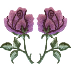 May include: Two embroidered iron-on patches featuring a rose flower design. Each rose has light purple petals with dark purple shading, a green stem, and two green leaves. The embroidery shows detailed stitching patterns on the petals and foliage.