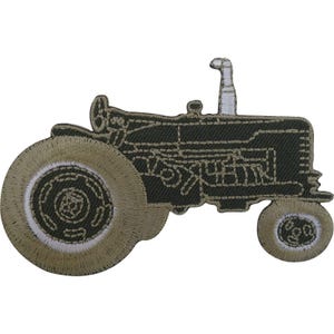 May include: An embroidered patch shaped like a farm tractor in dark olive green and tan thread. The design features a large rear wheel, a smaller front wheel, and a vertical exhaust pipe, all outlined with detailed stitching in a neutral palette.