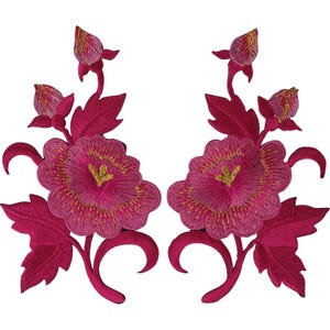 Op de afbeelding: Twee symmetrische geborduurde patches met levendige fuchsia bloemen en goudkleurige draadaccenten in het midden. Elke patch toont een grote centrale bloem, twee kleinere bloemknoppen en gedetailleerde gekartelde bladeren aan gebogen stengels.