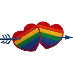 Puede incluir: Un parche bordado que muestra dos corazones superpuestos, cada uno relleno con rayas horizontales en rojo, naranja, amarillo, verde, azul y morado. Una flecha azul con plumas en la cola y punta afilada atraviesa ambos corazones horizontalmente.